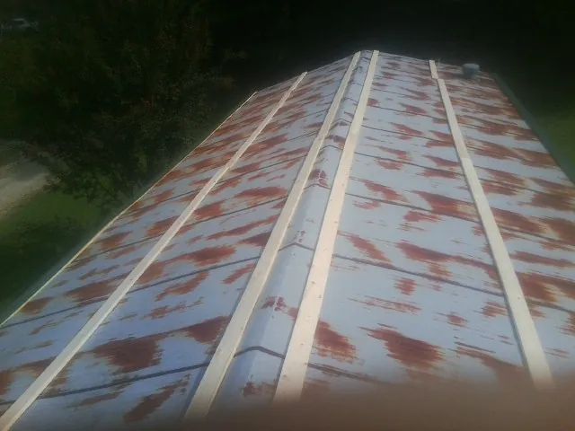 Rusted metal roof panels with new wood purlins before replacement — Storm Damage Roof Repair in Benson by Roofing Brothers