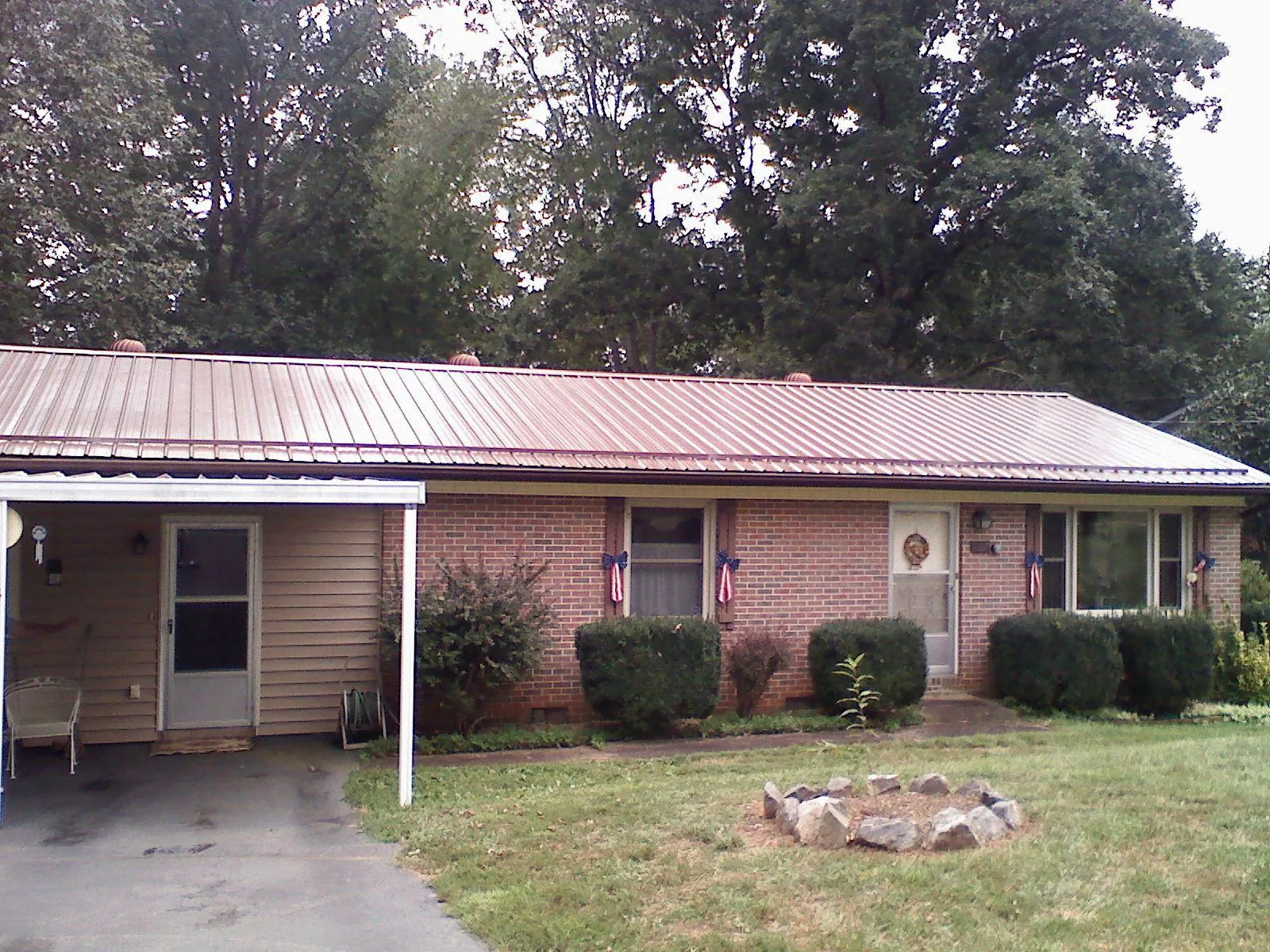 Bronze metal roof and carport on a brick ranch home — Roof Repair work by our crew in Benson